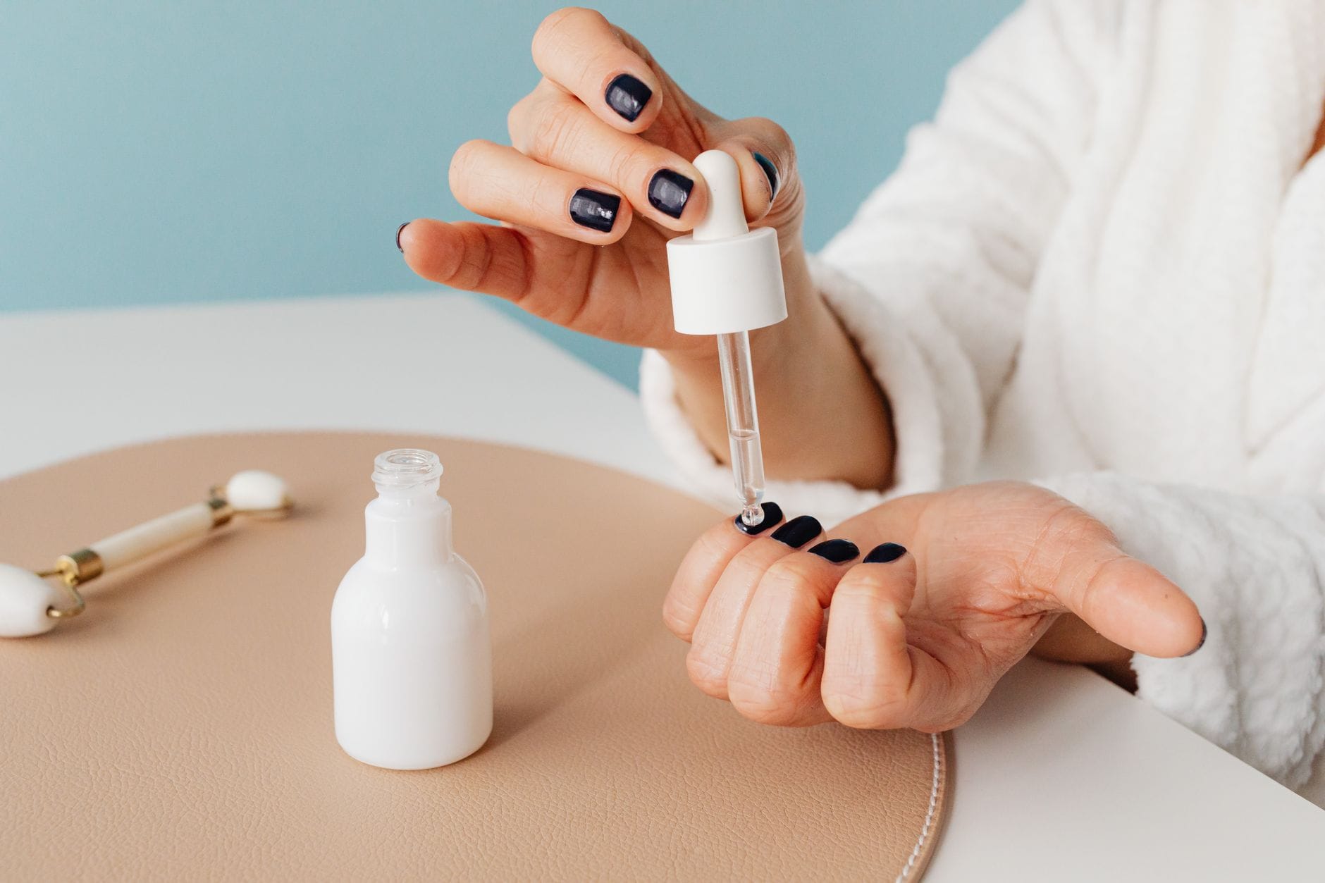 Dłoń nakłada serum do twarzy pipetą jako przykład nanokosmetyku